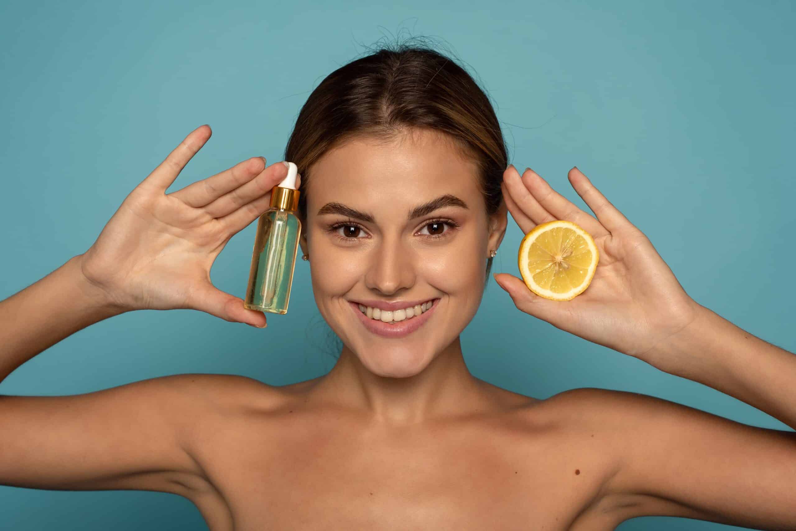 young girl smiling holding a lemon and face oil